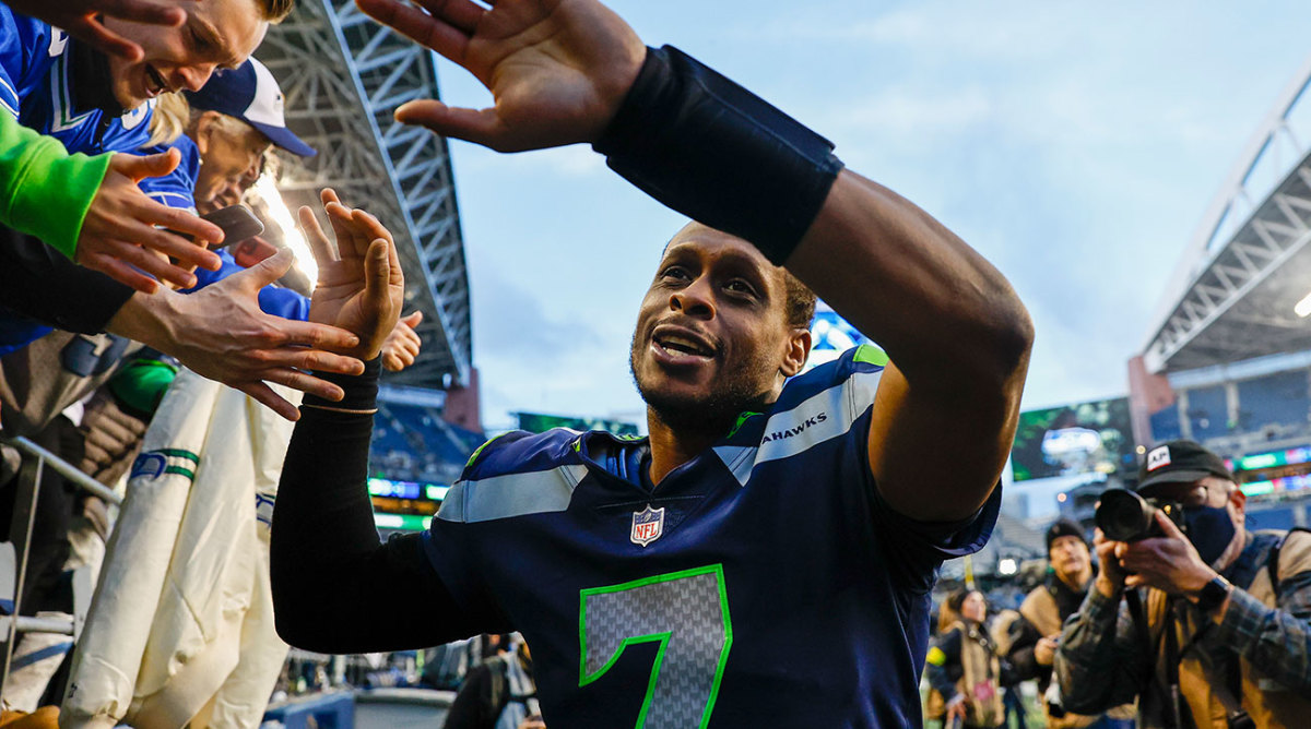 Geno Smith high-fives fans as he exits the field